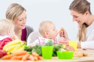 Un bébé mange avec l'aide d'une nutritionniste