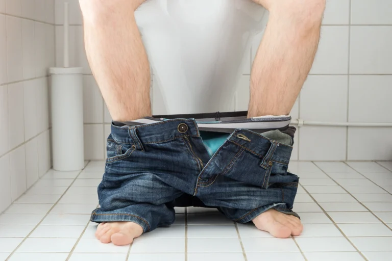 homme assis sur des toilettes